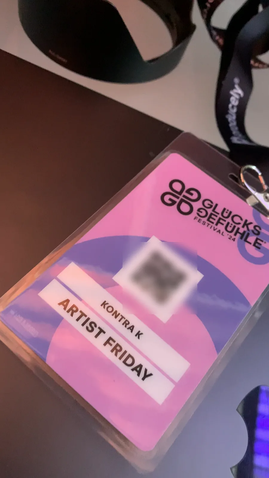 Festivalpass mit der Aufschrift „Kontra K – Artist Friday“ neben Kameratechnik